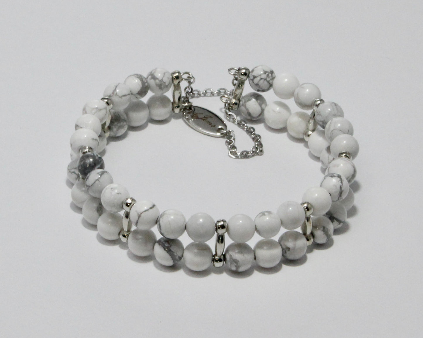 Handmade Howlite Bracelet showcasing 10mm white beads with soft gray veining on plated stainless steel memory wire with a fixed safety chain.