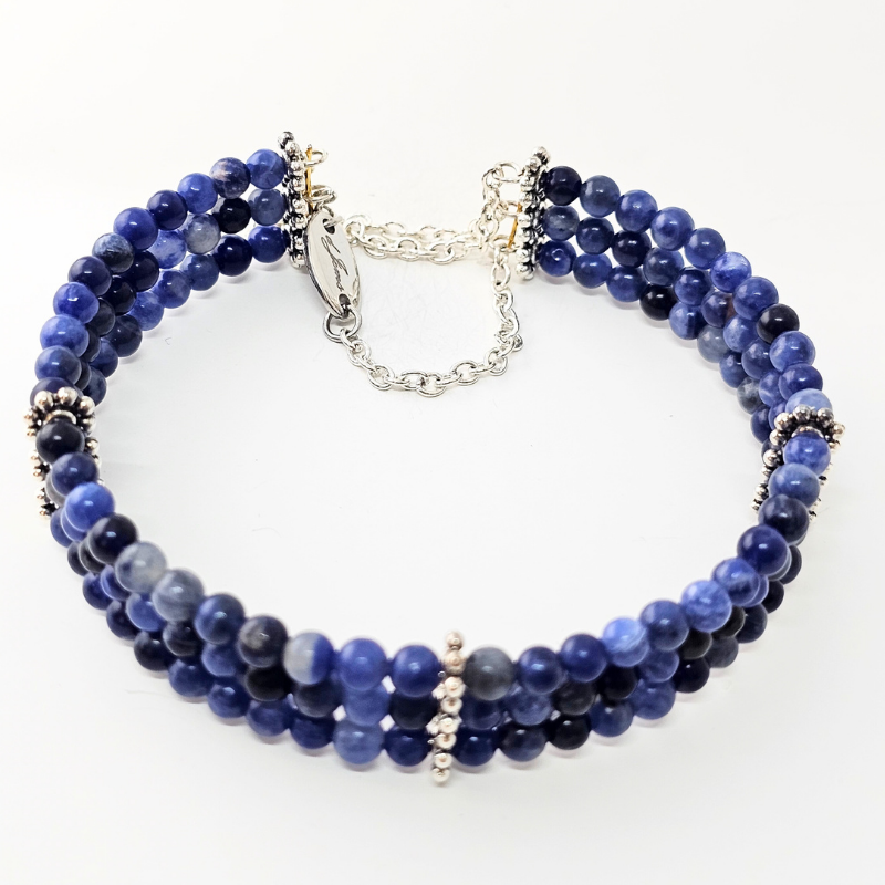 Sodalite 4mm Triple Strand Bracelet featuring deep blue beads on silver-plated memory wire with a fixed safety chain.