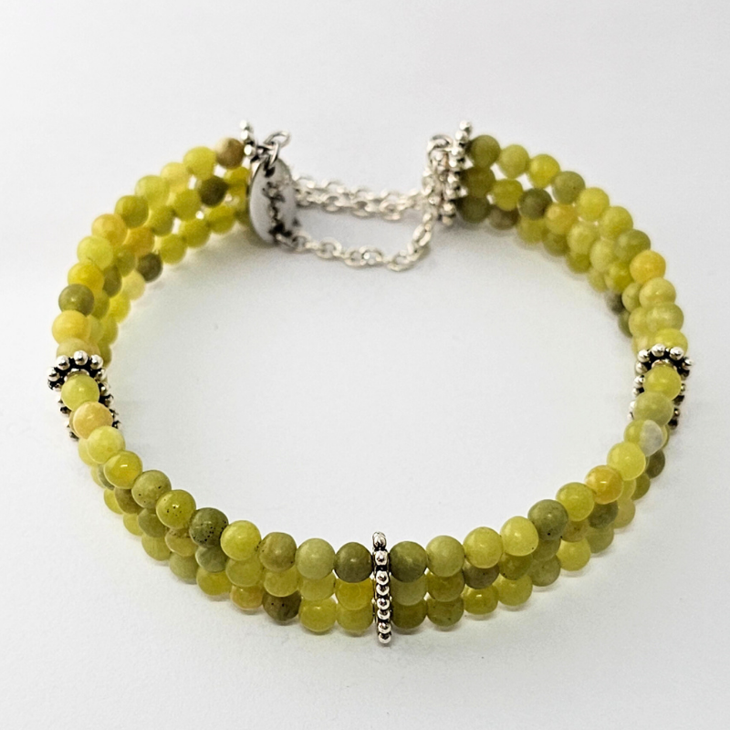 Taiwan Jade 4mm Triple Strand Bracelet featuring smooth green beads on silver-plated memory wire with a fixed safety chain.