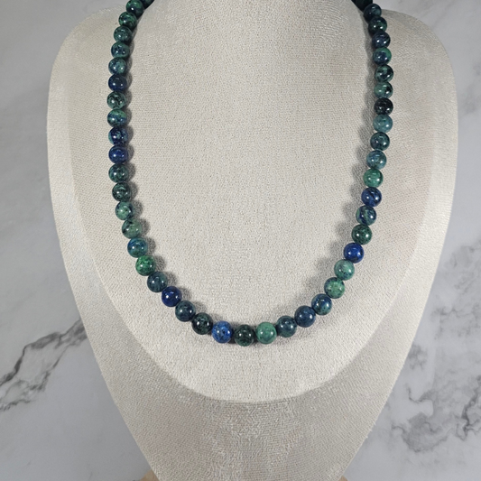 Beaded necklace on a mannequin bust with a marble background