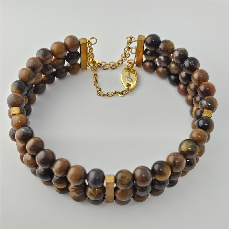 Triple strand bracelet made of 6mm polished Tiger’s Eye beads in rich brown and golden tones, accented with gold spacers and a gold chain clasp.