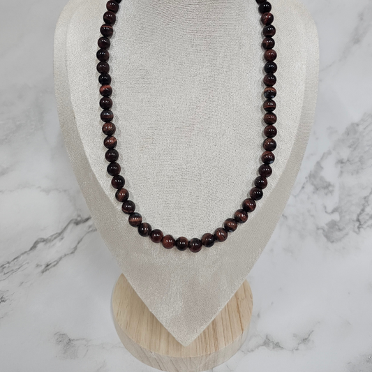 Beaded necklace on a mannequin bust against a marble background