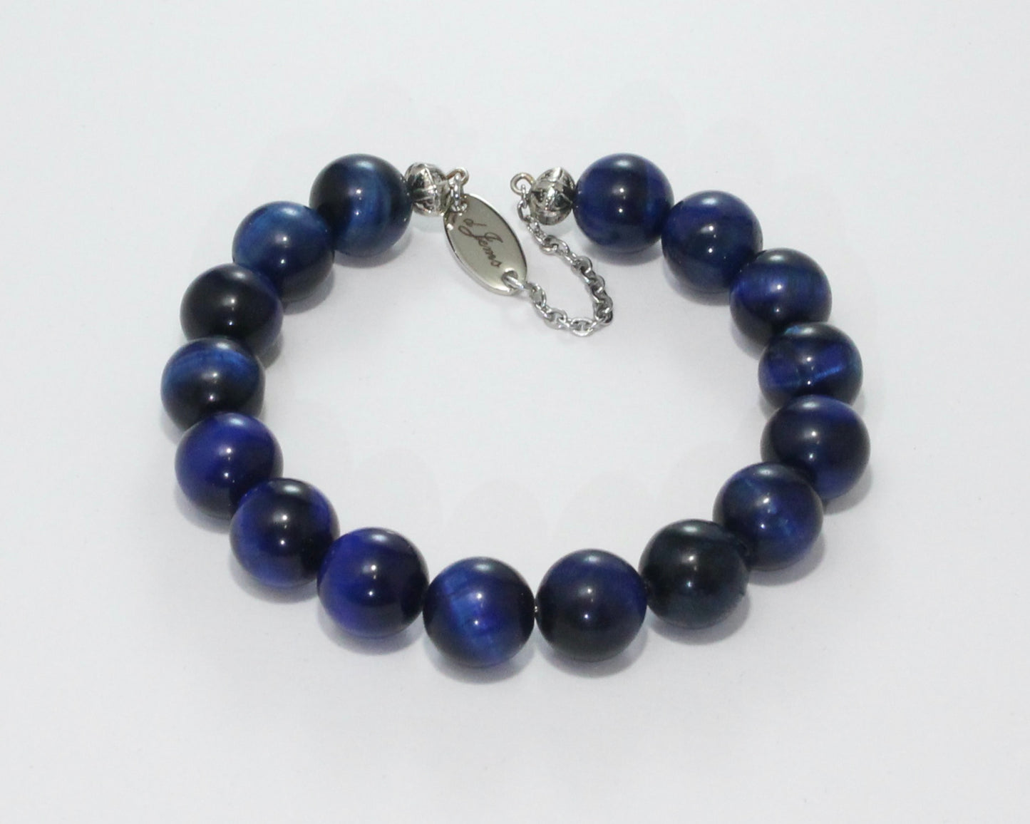 Handmade Blue Tiger's Eye Bracelet showcasing 10mm deep blue beads on plated stainless steel memory wire with a fixed safety chain.