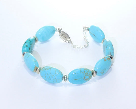 Handmade Blue Howlite Bracelet showcasing 17x12mm sky-blue beads with white veining on plated stainless steel memory wire with a fixed safety chain.