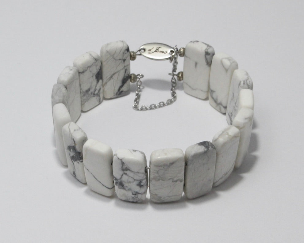 Handmade White Howlite Bracelet featuring 20x10mm white howlite beads with gray veining on plated stainless steel memory wire with a fixed safety chain.