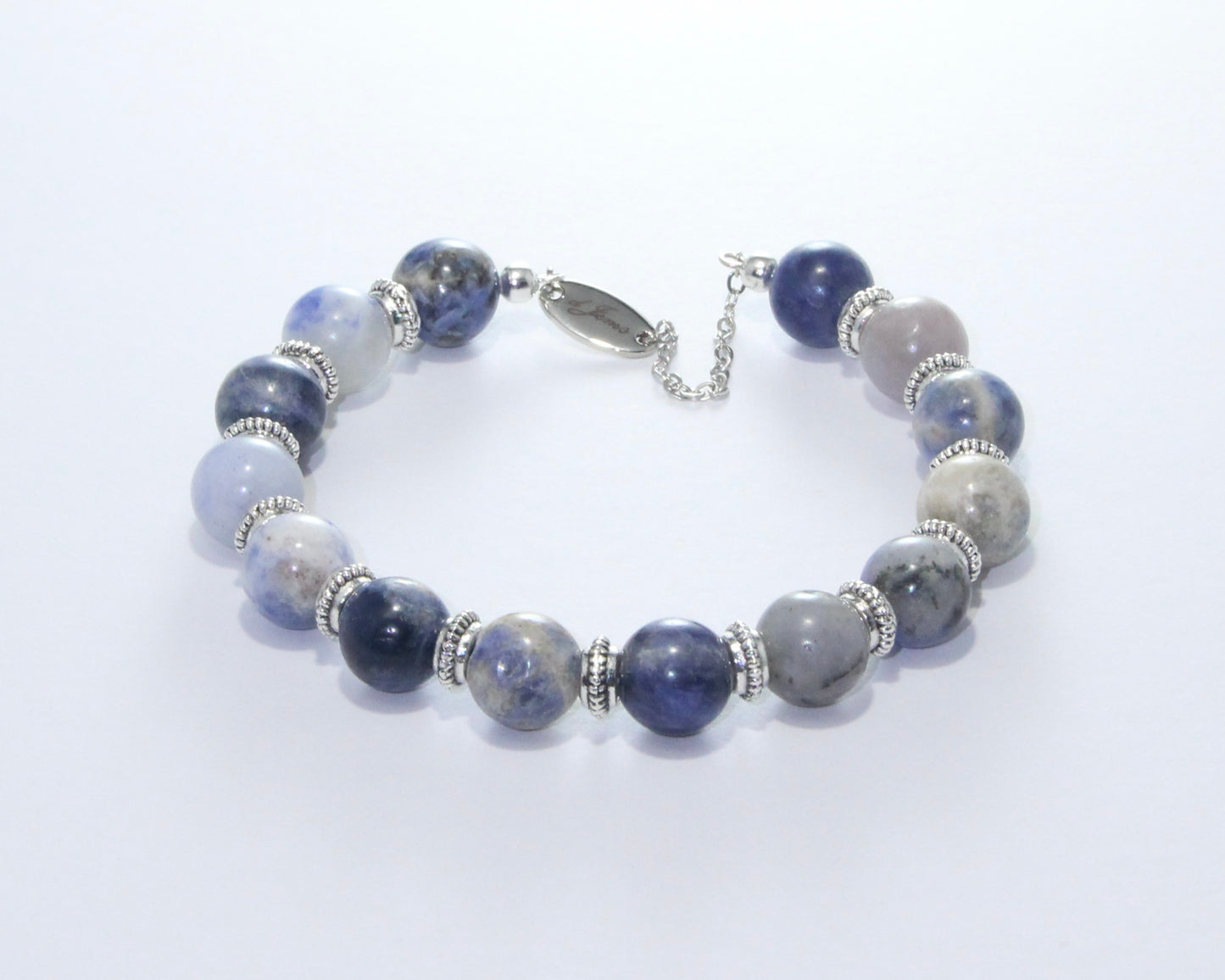 Handmade Sodalite Bracelet featuring 10mm royal blue beads with creamy white veins and elegant spacers on plated stainless steel memory wire with a fixed safety chain.