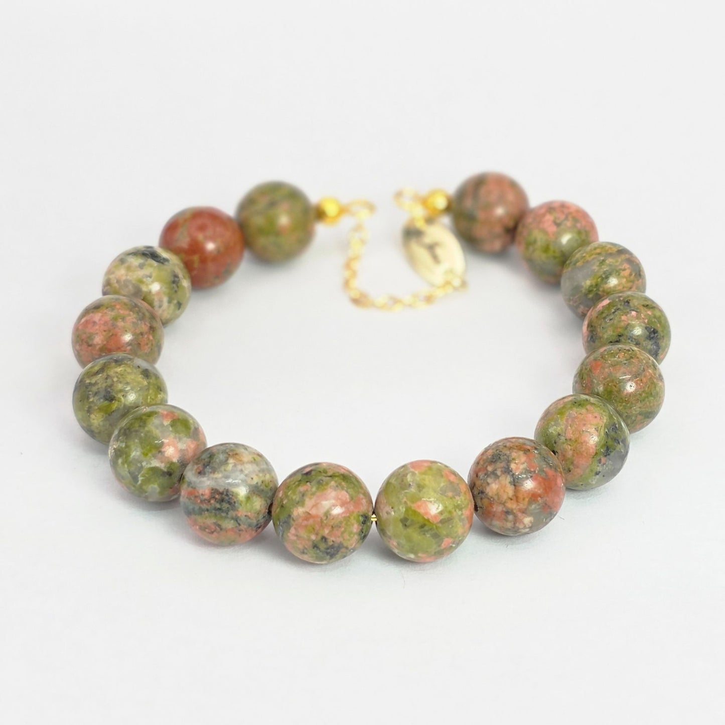 Green and red beaded bracelet on a white background