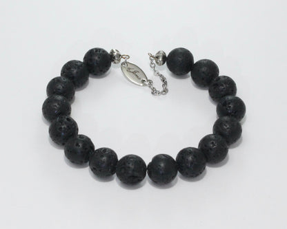 Handmade Black Lava Rock Bracelet showcasing 10mm natural lava rock beads on plated stainless steel memory wire with a fixed safety chain.