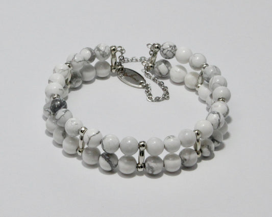 Handmade Howlite Bracelet showcasing 10mm white beads with soft gray veining on plated stainless steel memory wire with a fixed safety chain.


