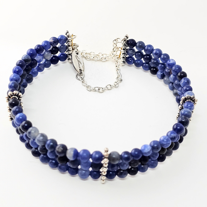 Sodalite 4mm Triple Strand Bracelet featuring deep blue beads on silver-plated memory wire with a fixed safety chain.