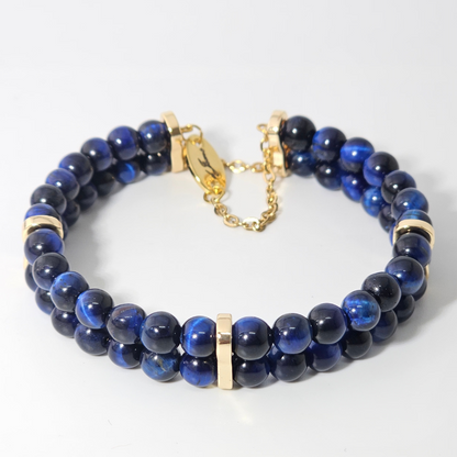 Elegant Blue Tiger’s Eye 6mm double strand bracelet featuring polished deep blue beads, gold accent spacers, and a gold clasp with adjustable chain.