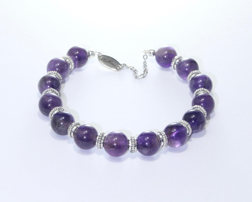 Handmade Black Tourmaline Bracelet featuring 10mm deep black beads with elegant spacers on plated stainless steel memory wire with a fixed safety chain.