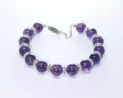 Handmade Black Tourmaline Bracelet featuring 10mm deep black beads with elegant spacers on plated stainless steel memory wire with a fixed safety chain.