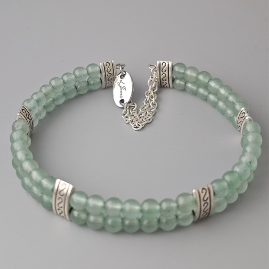 Double strand bracelet made of 4mm green aventurine beads, accented with silver-toned spacers and a delicate silver chain clasp featuring an engraved tag.