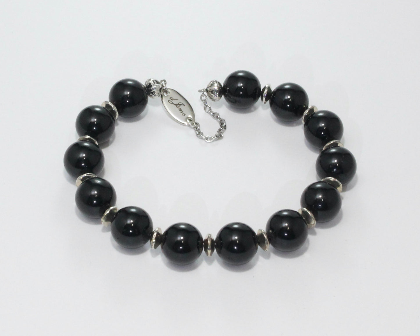 Handmade Black Tourmaline Bracelet showcasing 10mm deep black tourmaline beads with elegant spacers on plated stainless steel memory wire with a fixed safety chain.