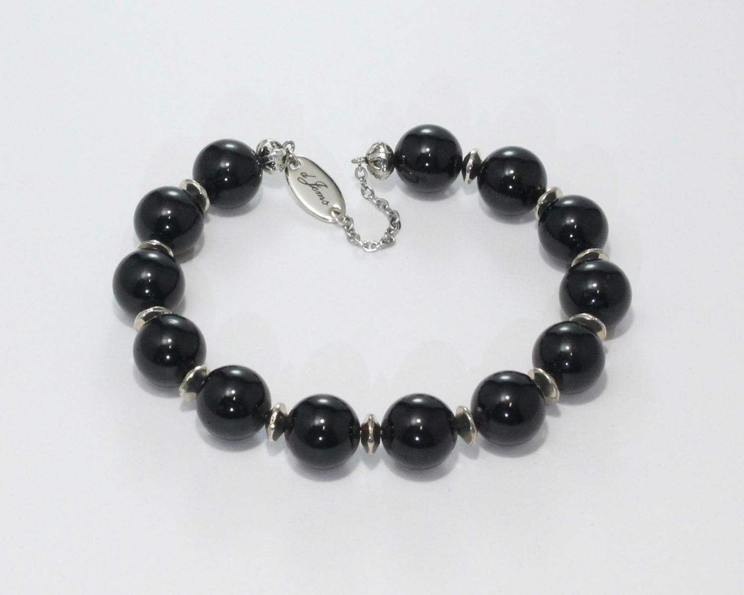 Handmade Black Tourmaline Bracelet showcasing 10mm deep black tourmaline beads with elegant spacers on plated stainless steel memory wire with a fixed safety chain.