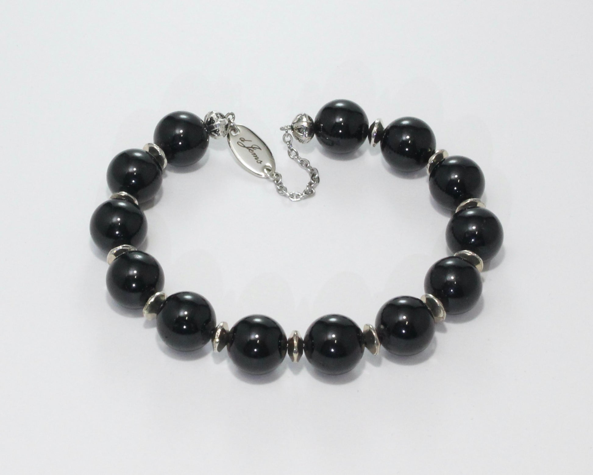 Handmade Black Tourmaline Bracelet showcasing 10mm deep black tourmaline beads with elegant spacers on plated stainless steel memory wire with a fixed safety chain.