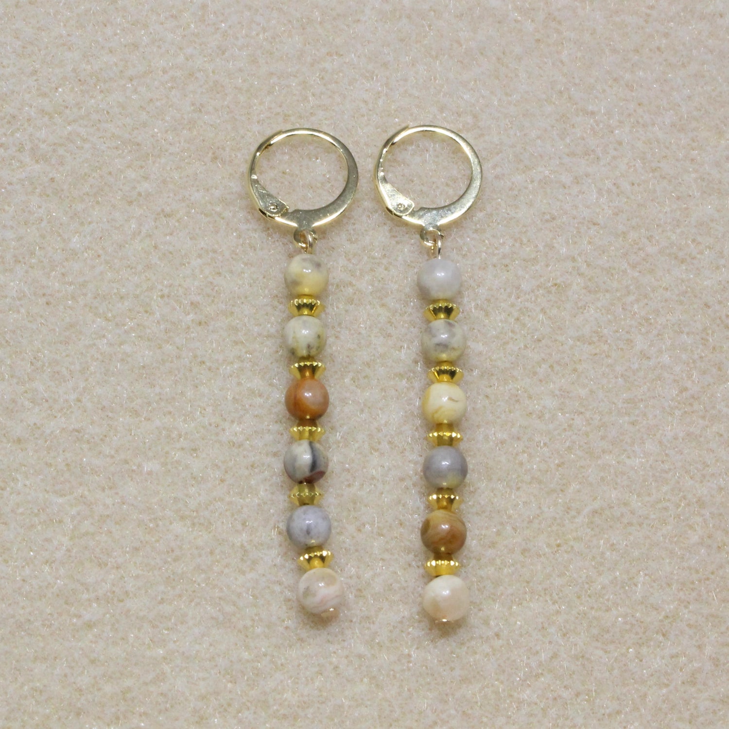 Handmade Crazy Lace Agate Dangle Earrings featuring natural gemstone swirls in red, brown, and cream hues on gold-tone lever-back hooks.