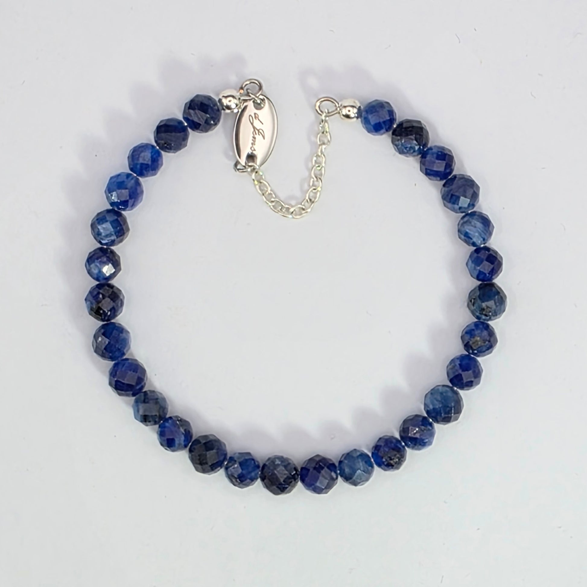 Blue beaded bracelet with silver clasp on a white background