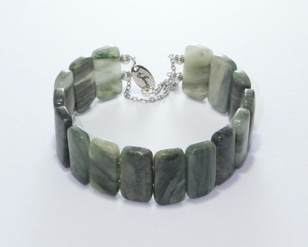 Handmade Seraphinite Bracelet showcasing 10mm natural green beads with feather-like patterns on plated stainless steel memory wire with a fixed safety chain.
