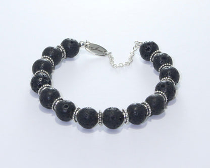 Handmade Black Lava Rock Bracelet showcasing 10mm black lava beads with elegant spacers on plated stainless steel memory wire with a fixed safety chain.
