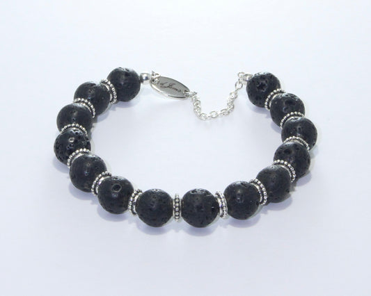 Handmade Black Lava Rock Bracelet showcasing 10mm black lava beads with elegant spacers on plated stainless steel memory wire with a fixed safety chain.