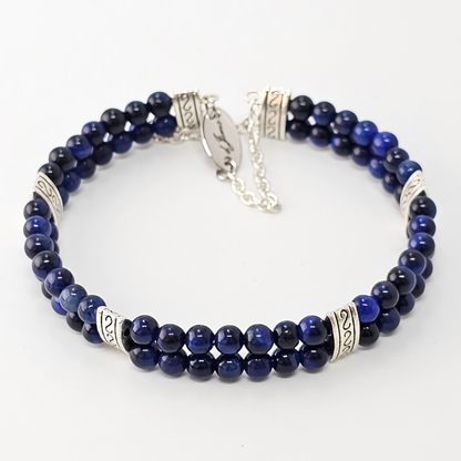 Blue Tiger's Eye 4mm Double Strand Bracelet featuring deep blue beads with natural chatoyancy on silver-plated memory wire, secured with a fixed safety chain.