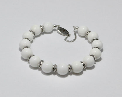 Handmade White Angelite Bracelet showcasing 10mm white angelite beads with elegant spacers on plated stainless steel memory wire with a fixed safety chain.