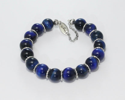 Handmade Blue Tiger's Eye Bracelet showcasing 10mm deep blue beads with elegant spacers on plated stainless steel memory wire with a fixed safety chain.