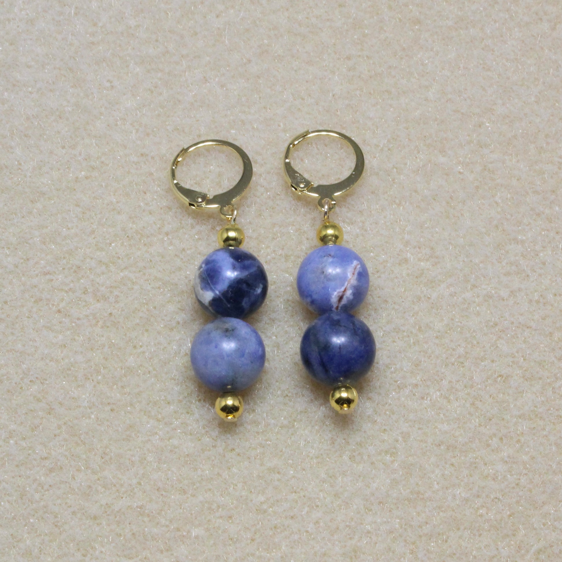 Pair of Sodalite Drop Earrings showcasing 8mm natural blue stones with lever-back closures, highlighting the stone's unique patterns.