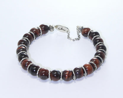 Handmade Red Tiger's Eye Bracelet showcasing 10mm deep red beads on plated stainless steel memory wire with a fixed safety chain.

