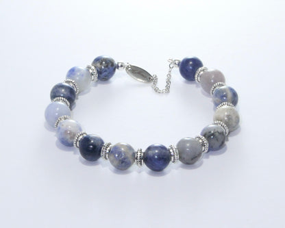 Handmade Sodalite Bracelet featuring 10mm royal blue beads with creamy white veins and elegant spacers on plated stainless steel memory wire with a fixed safety chain.