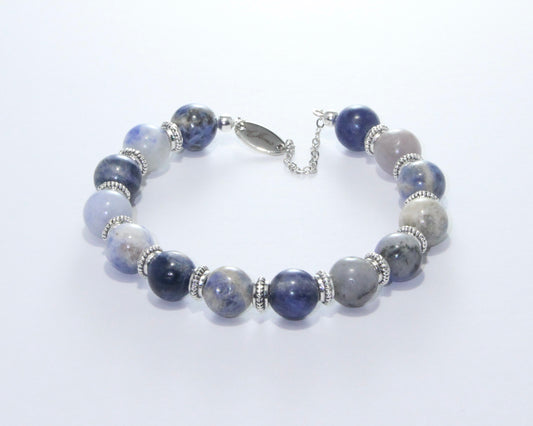 Handmade Sodalite Bracelet featuring 10mm royal blue beads with creamy white veins and elegant spacers on plated stainless steel memory wire with a fixed safety chain.