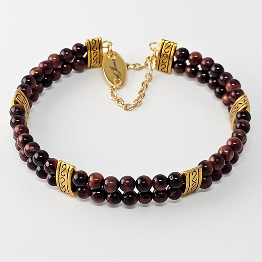Close-up of the Red Tiger’s Eye 4 mm double-strand bracelet, showcasing two rows of polished deep reddish-brown gemstone beads with gold-tone spacer accents and a delicate gold chain clasp, set against a white background.