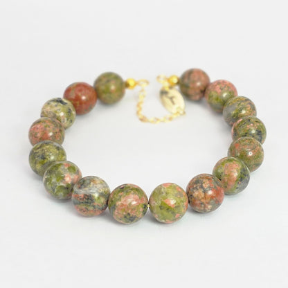 Green and red beaded bracelet on a white background
